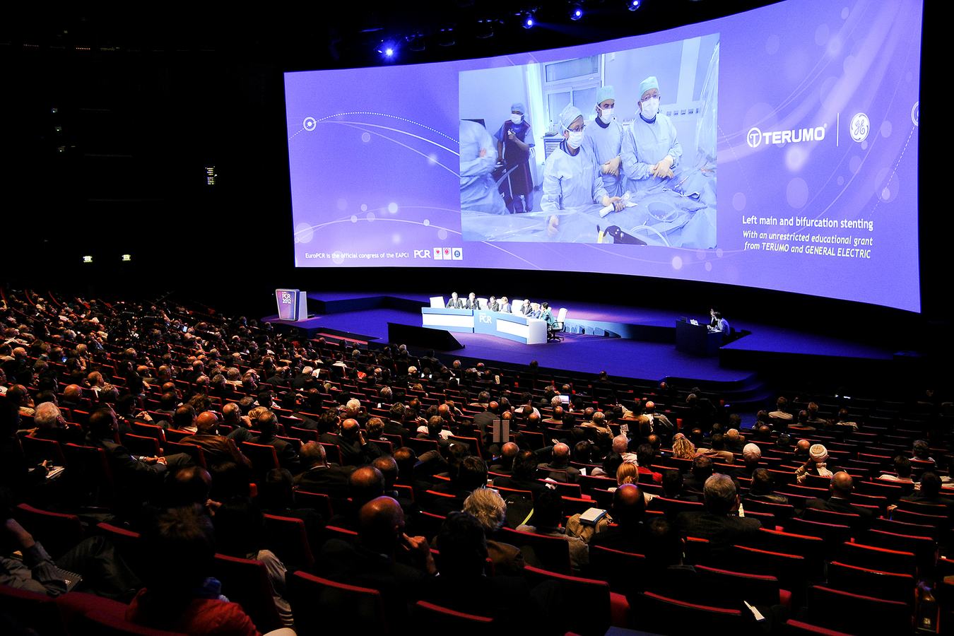 Plénière en amphithéâtre : grand écran de projection et salle complète