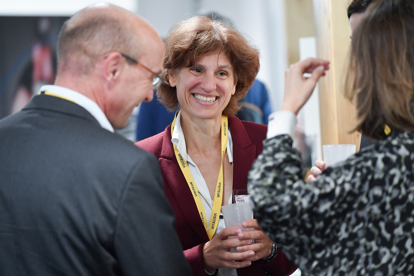 Échanges entre participants badgés pendant un cocktail de networking