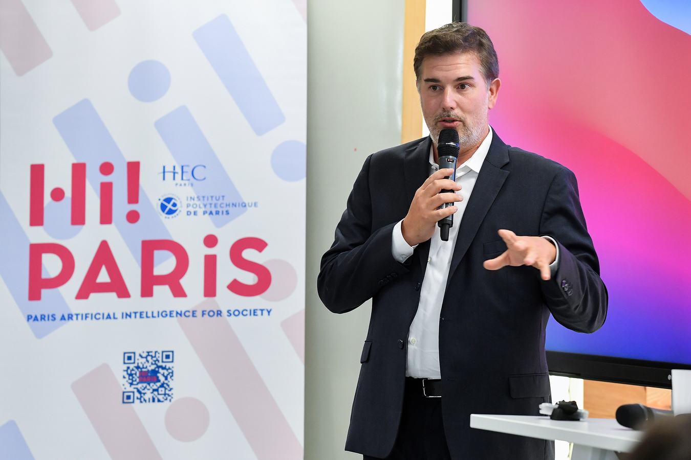 Orateur au micro lors d'une rencontre en école supérieure